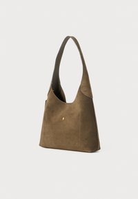 Brown suede shoulder bag with a curved shape, top handle, a front pocket, and a small gold accent on the front. Sides are stitched.