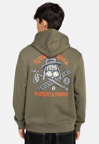 Haut à capuche vert olive en mélange de coton, orné d'un imprimé graphique d'un chien de dessin animé portant un chapeau avec le texte « RIDE RAILS » en orange au dos.