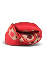 Red rubber shoe with a beige fabric lining featuring a pattern of small red circular designs and cartoon-style eyes. Smooth and flexible texture.