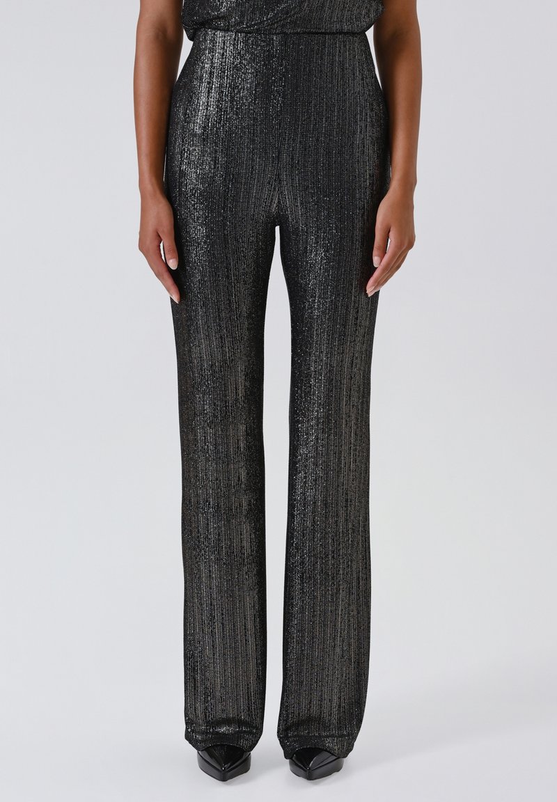 Pantaloni neri a gamba larga realizzati in un tessuto lucido e testurizzato con righe verticali. Presentano una vita alta e una silhouette svasata.