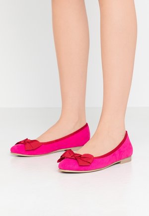 Fuchsia ruskinds balletflade med en rød sløjfe, flade såler og en glat tekstur. Rund tå og kontrastbånd.
