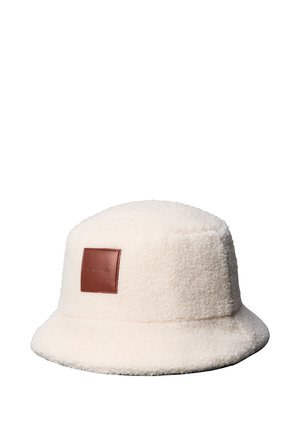 Cappello bucket in pile color crema con toppa quadrata in pelle marrone con il nome del marchio in rilievo centrato sulla parte frontale.