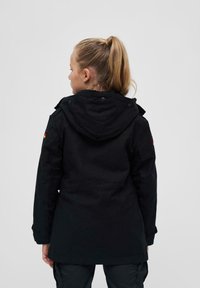 Črna jopica s kapuco z teksturirano površino, ki vključuje mehak oblazinjeni notranji del, nastavljive manšete in majhen detajl z zastavo na levem roki.