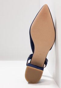 Chaussure plate bleu marine à bout pointu avec semelle beige texturée, bride à la cheville et petit talon carré, taille 37, fabriquée en Espagne.