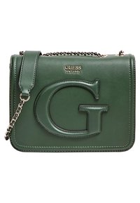 Tmavě zelená dámská taška Guess přes rameno s velkým embosovaným "G," zlatým řetízkovým popruhem a logem GUESS EST 1981 na předním klopě.