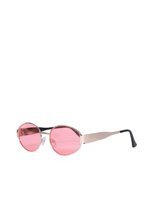 Occhiali da sole rotondi con lenti sfumate rosa, sottile montatura in metallo e terminali delle aste neri curvi su sfondo bianco.