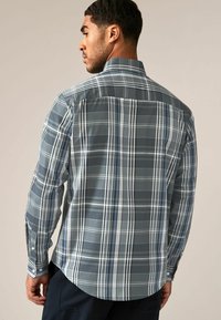 Heren overhemd met lange mouwen in grijs, voorzien van een geruit patroon met blauwe en witte accenten. Gemaakt van een gladde stof met een afgeronde zoom.