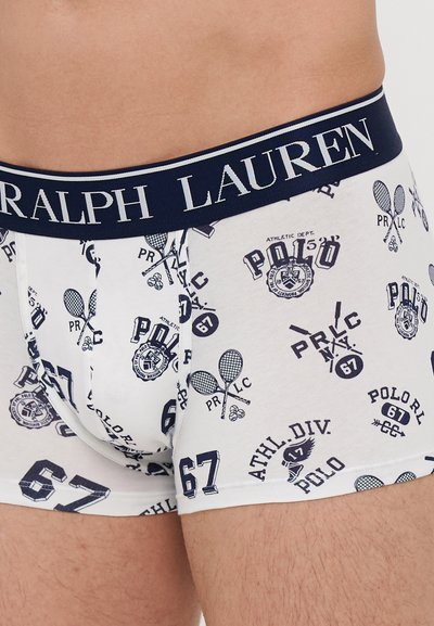 Valkoiset puuvillaboksereiden alushousut, joissa on tummansininen vyötärönauha, jossa lukee "RALPH LAUREN"; koristeltu urheiluteemaisilla grafiikoilla ja numeroilla tummansinisessä värissä.