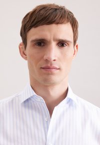 Biała koszula z jasnoniebieskimi paskami, kołnierzykiem na guziki oraz gładką fakturą, noszona przez osobę na neutralnym tle.