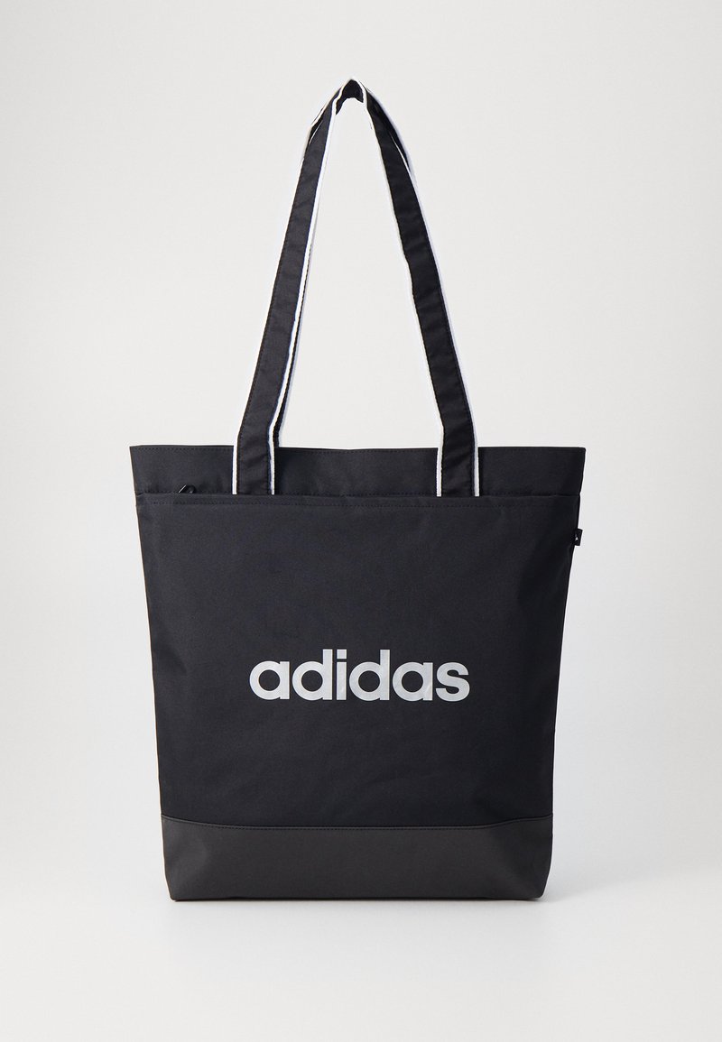 Black tote bag with gray "adidas" logo, made of durable fabric, featuring two shoulder straps and a contrasting black bottom panel.