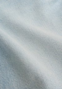 Jasnoniebieska tkanina dżinsowa o gładkiej fakturze, z delikatnym skośnym wzorem splotu i lekkim blaknięciem dla miękkiego wyglądu.