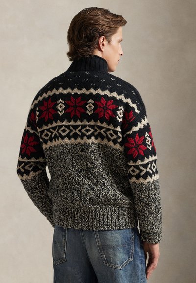 Knit black sweater with multicolored patterns, featuring red floral designs, cream accents, and a high collar. Textured and cozy appearance.