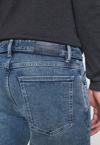 Jeans i denim med en blekt blå färg och rak skärning. Funktioner inkluderar en läderetikett med "CLOSED" och två bakfickor.