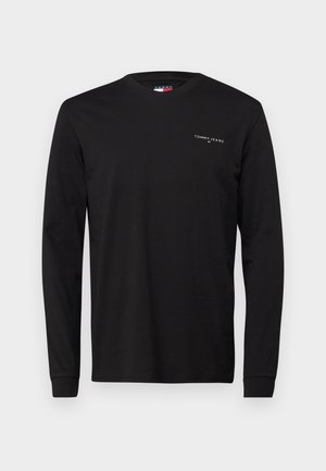 Schwarzes Langarm-T-Shirt aus Baumwolle mit Rundhalsausschnitt und kleinem weißen "TOMMY JEANS"-Logo auf der oberen linken Brust.