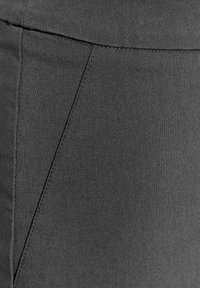 Tejido gris con un aspecto texturizado, que presenta una costura diagonal sutil y una superficie lisa. Sin patrones visibles ni detalles de hardware.