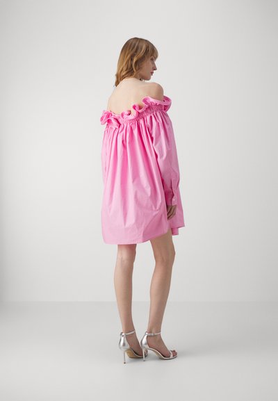 Šviesiai rožinė, off-the-shoulder, volanėliuota suknelė iš medvilnės, laisva, su ilgomis rankovėmis, derinama su sidabriniais kulkšnies dirželiais.