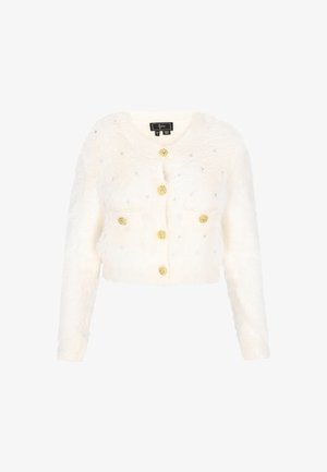 Balta dirbtinio kailio trumpa kardiganas su ilgomis rankovėmis, puošia aukso mygtukai ir išdėstyti deimantukai. Lygus paviršius ir paprastas dizainas.