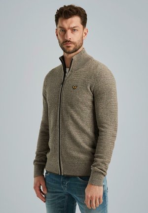 Gebreide ritscardigan in beige met een gestructureerd patroon, voorzien van een hoge kraag en zwarte rits; klein geborduurd logo op de borst.