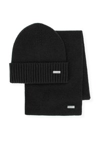 Czarny dziany komplet czapka i szalik. Czapka ma wywinięty brzeg, a oba elementy mają gładką fakturę z małą metką z logo.
