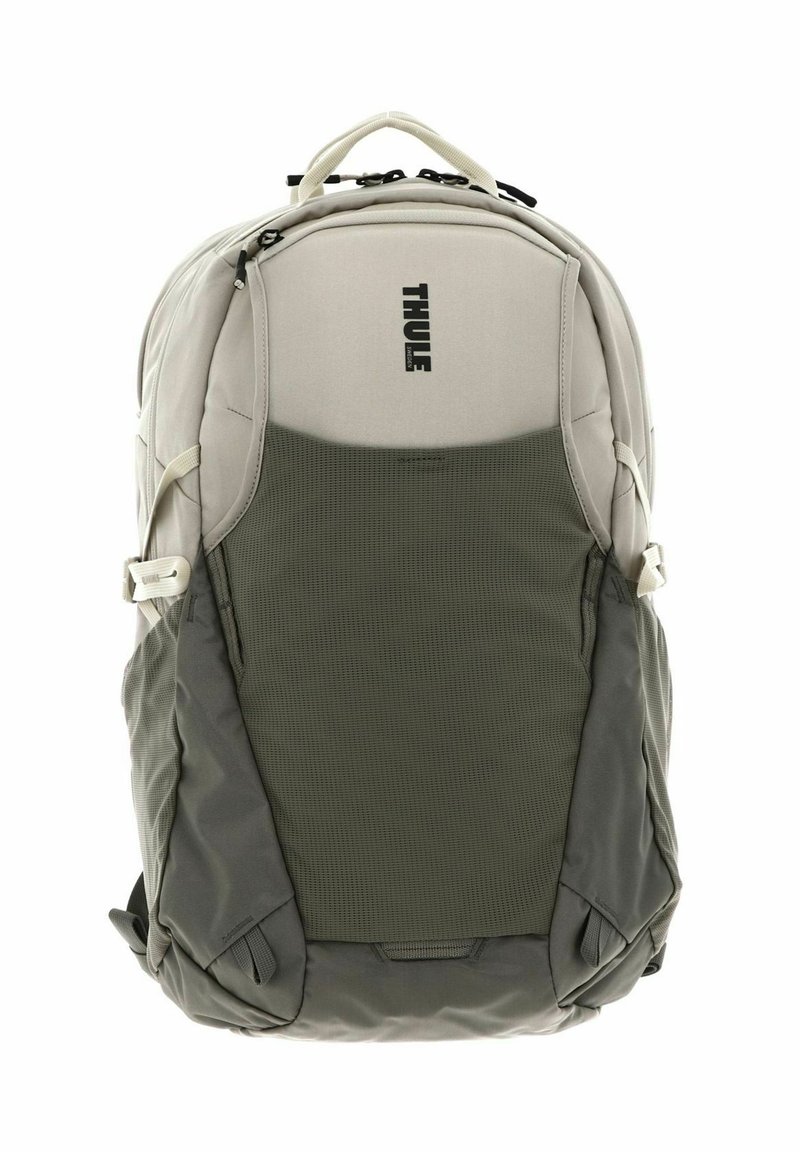 Zaino Thule di colore grigio chiaro con una sezione inferiore verde testurizzata. Presenta cerniere, tasche laterali e una maniglia di trasporto superiore.