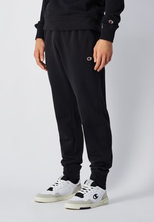 Sorte sweatpants lavet af en bomuldsblanding, med en tapered fit, elastisk talje og sidelommer. Accentueret med et lille broderet logo.