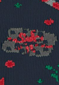 Dzianina o ciemnoniebieskiej bazie, z wzorem szarych, czerwonych i zielonych abstrakcyjnych kształtów oraz faktur w całej powierzchni.