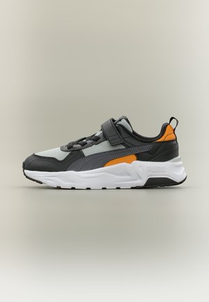 Chaussure de sport grise, noire et orange avec semelle blanche, lacets à l'avant et une seule bride Velcro, montrée en profil droit.