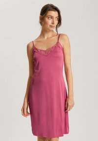 Vaaleanpunainen liukuväri mekko, joka on valmistettu sileästä kankaasta, jossa on säädettävät spagettiolkaimet ja pitsireunainen V-kaula-aukko.