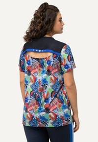Top de manga corta con una parte superior en azul marino, un vibrante patrón floral en rojo, azul y verde, y un corte decorativo con botones en la parte posterior.