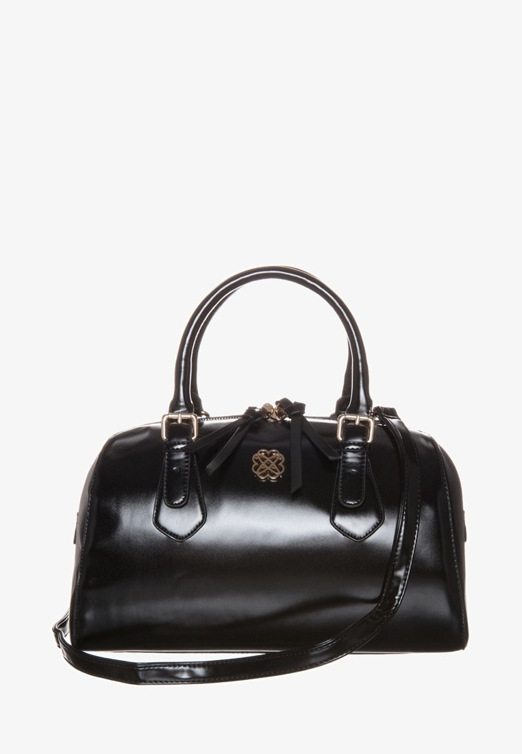 Sac à main noir brillant avec double poignée, une bandoulière amovible, un emblème décoratif doré central et une fermeture éclair avec pompons.