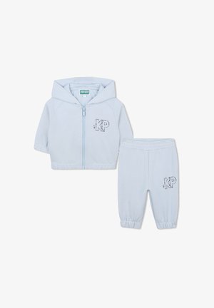 Veste à capuche bleu clair zippée avec pantalon assorti, dotés de poignets élastiques et du logo "KP" orné de strass. Texture de tissu douce.