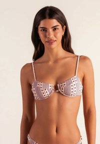 Sujetador de bikini con aros, que presenta un patrón a rayas en lavanda y crema, y lunares, con tirantes delgados ajustables y una textura suave.