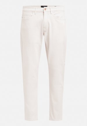 Light beige denim pants with a slim fit, featuring a zip fly, button closure, five pockets, and minimal stitching details.