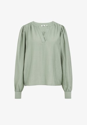Gai zaļas krāsas garām piedurknēm blūze ar V-veida izgriezumu, saveltiem pleciem un pieguļošiem aprocēm.