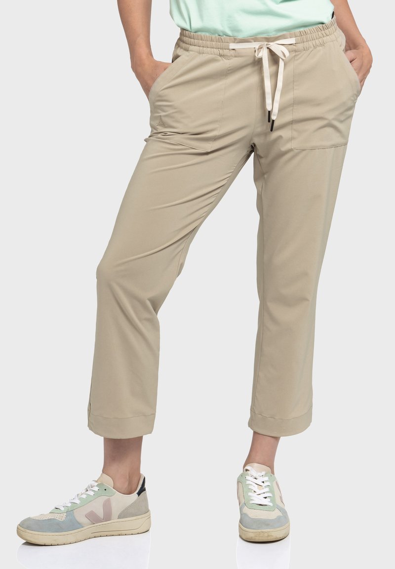 Beige, leichte, schmal zulaufende Hose mit elastischem Bund und weißem Kordelzug. Verfügt über Seitentaschen und cropped Länge.
