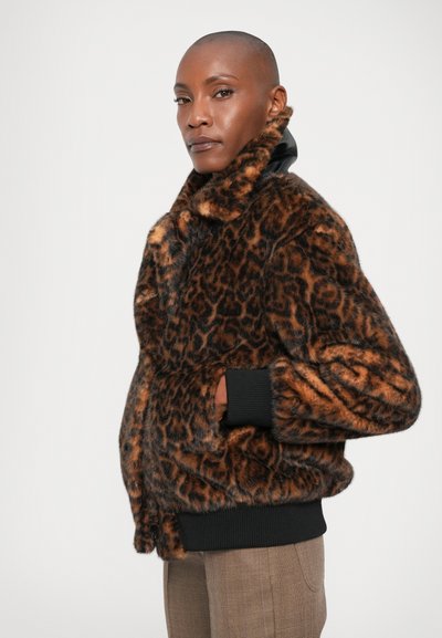 Casaco de pelúcia com padrão de leopardo, com gola alta, punhos de malha pretos e bolsos laterais. Textura suave e aparência quente.