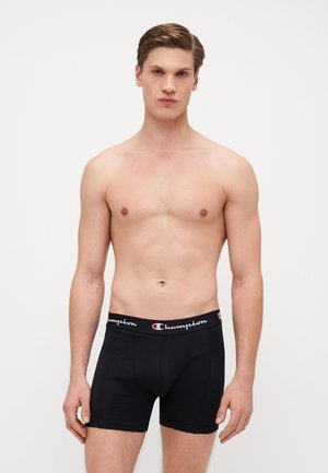 Schwarze elastische Boxershorts mit einem Logo-Bund. Der Stoff wirkt glatt und zeigt ein enganliegendes Design mit leichtem Stretch am Bund.