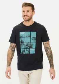 Marineblå bomulds t-shirt med et grafisk motiv bestående af ni rektangler i turkismet, prydet med teksturerede mønstre og hvid tekst "JAGT NYE HORISONTER."