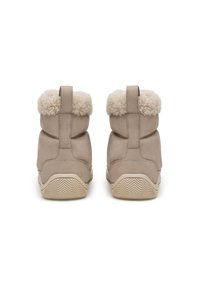 Bottines en suède beige avec un revers en fourrure crème duveteuse et une semelle en caoutchouc texturée, dotées d'une languette à l'arrière pour un enfilage facile.