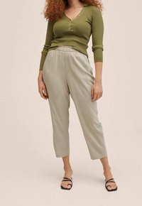 Olijfgroene geribbelde longsleeve met een V-hals en knopen, gecombineerd met lichtgrijze cropped broek met een elastische tailleband en een gladde textuur.