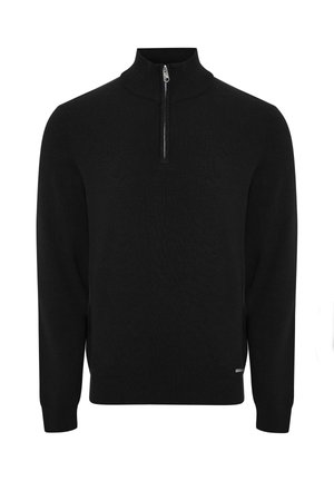 Schwarzer Strickpullover mit hohem Kragen und viertel Reißverschluss. Lange Ärmel und gerippte Bündchen, mit einem kleinen Logo am Saum.