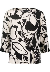 Blusa floral en blanco y negro con mangas tres cuartos. Presenta grandes patrones de hojas y corazones, escote redondo y un corte relajado.