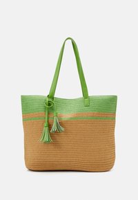 Bolso de tote tejido con rayas verdes y beige, que presenta una superficie texturizada, asas de cuero verde y borlas decorativas.