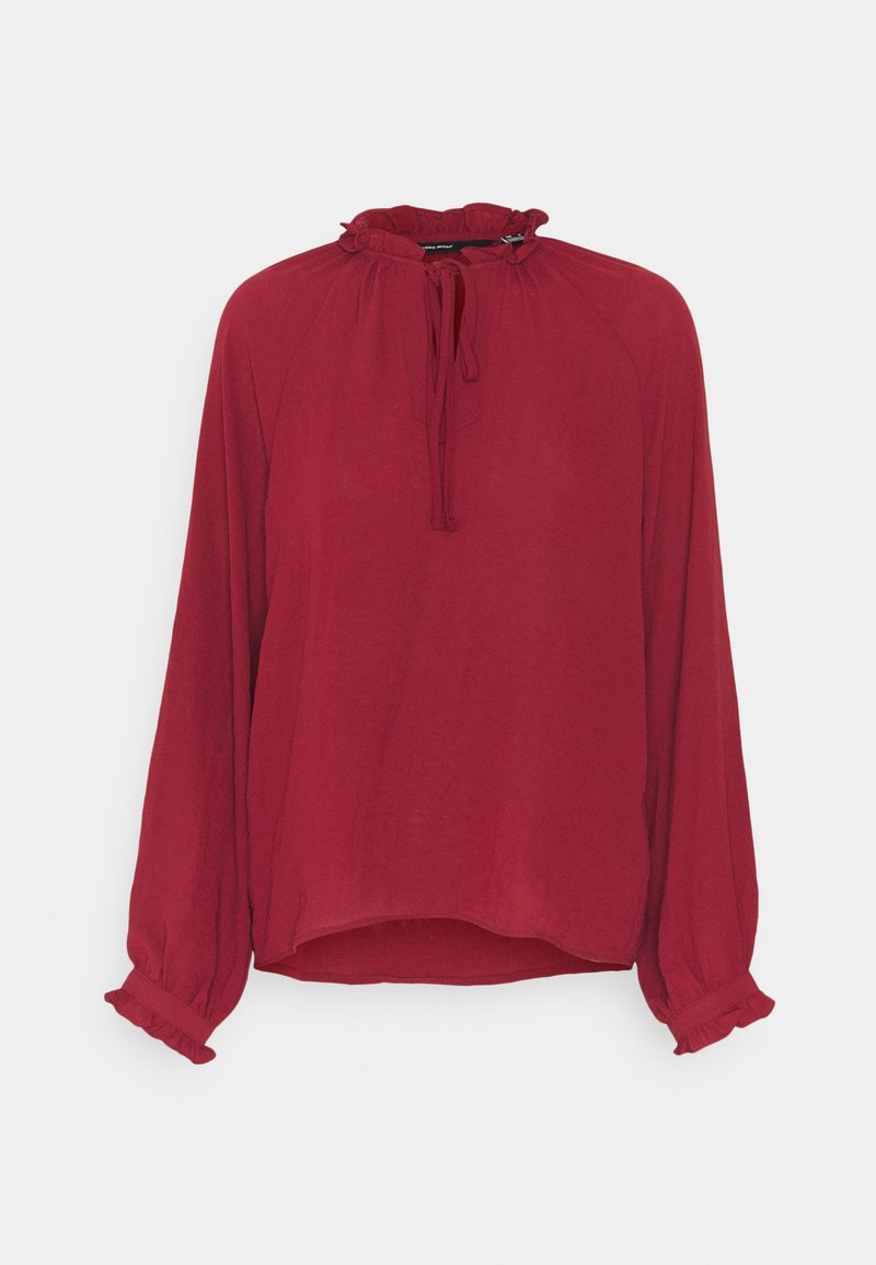 Blusa rossa a maniche lunghe con scollo arricciato, cordoncino e polsini arricciati. Tessuto morbido e design leggermente oversize.
