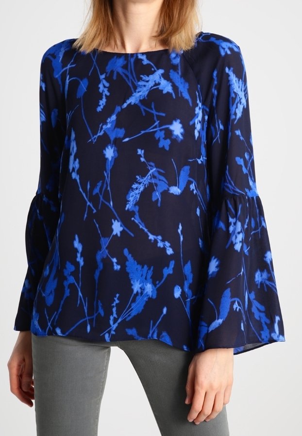 Námořnická blůza s modrým květinovým vzorem, zvonovými rukávy a kulatým výstřihem, vyrobená z lehkého materiálu. Viditelné švy na ramenou.