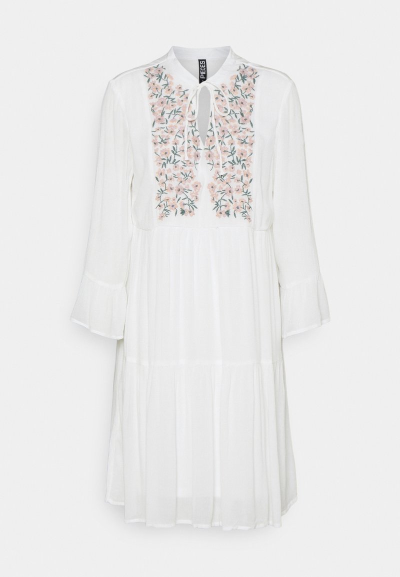 Robe blanche à manches longues avec broderie florale sur la poitrine, encolure goutte d'eau avec lien et panneaux de jupe à volants.