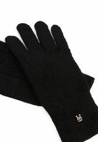Black knitted gloves with ribbed cuffs, featuring a small gold logo accent. Soft texture and full-finger coverage for warmth.