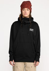 Sweatshirt noir avec col montant, poche avant et cordons de serrage. Le logo "VOLCOM STONE" est imprimé en blanc sur la poitrine gauche.