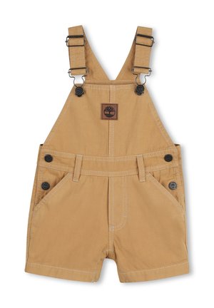 Helle Baumwolllatzhosen mit verstellbaren Trägern, Vordertaschen und schwarzen Knöpfen. Mit einem quadratischen Logoaufnäher mit Baum-Motiv.