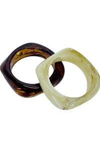 Dos anillos cuadrados hechos de resina translúcida; uno marrón oscuro con patrones ondulados, el otro verde pálido con un acabado suave.